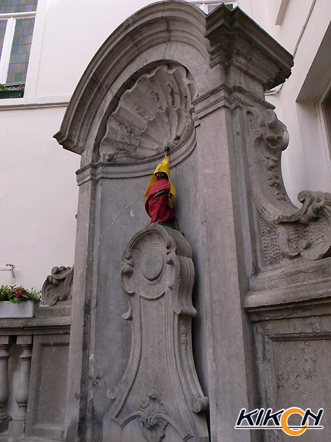 小便小僧の像。黄色の三角帽子と赤い布が巻かれている。