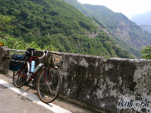 山道の途中にあるガードレールのコンクリートブロックに立て掛けて、自転車を停めている。