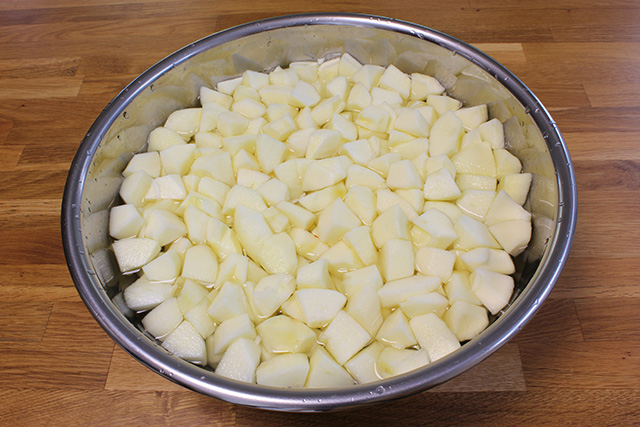 皮を剥かれ、2cm程に切られた紅玉が、ボウルで塩水につけられている