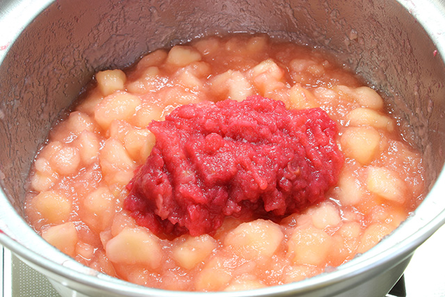 鍋で煮られている果肉の上に皮から削った果肉が加えられている