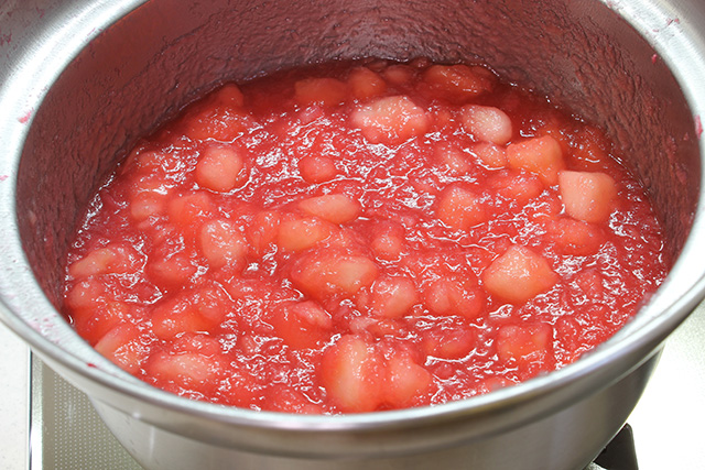 鍋の中で煮込まれ赤く色づいたペースト状の果肉