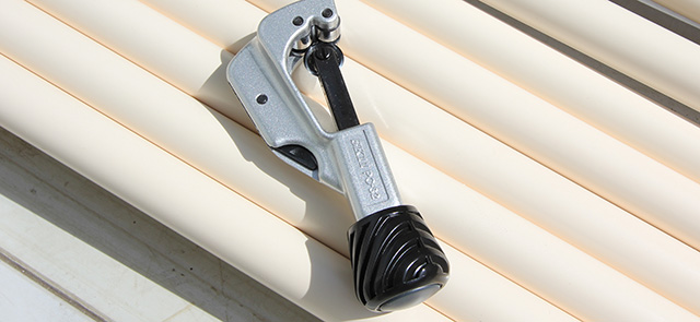 並べたパイプの上に置かれたパイプカッター