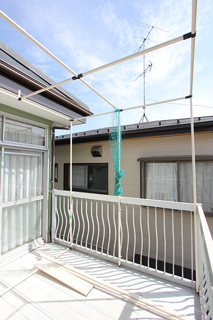 2階のベランダにパイプが藤棚状に組まれている、柱の1本にネットがくくられている
