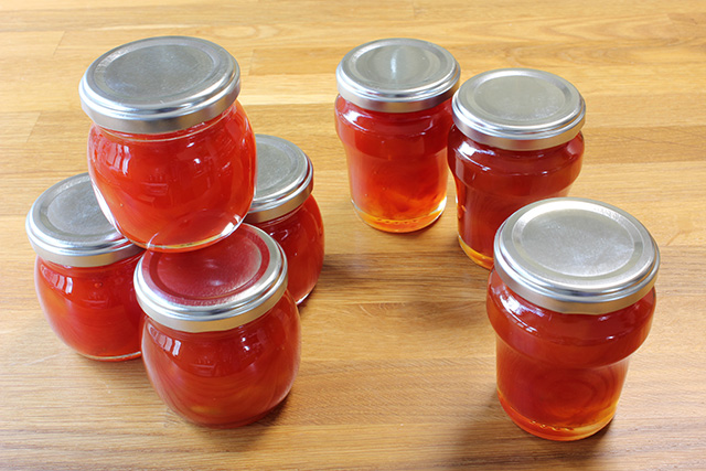 ７つの小瓶に詰められたスイカジャムが床に並べられている